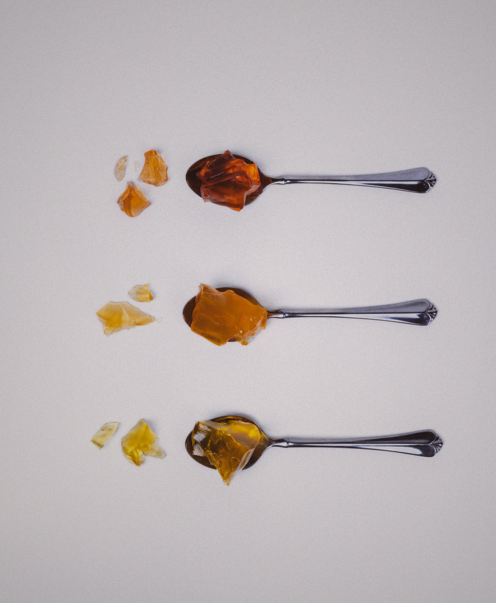 Three spoons with different gelatin flavors on a white background
